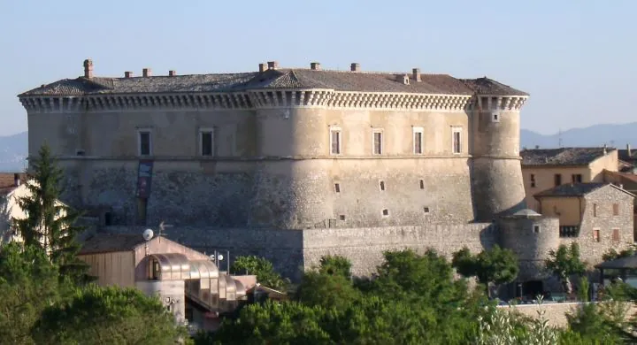 Il Castello di Alviano di giorno: edificio rinascimentale con torri circolari tra il verde